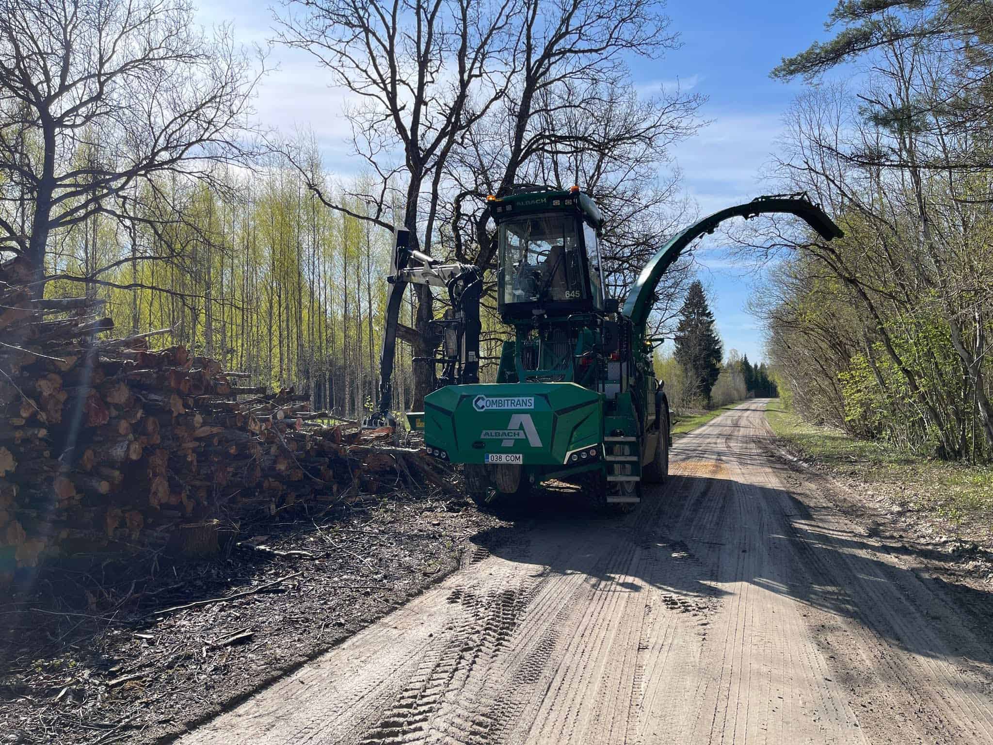 Combitransi mobiilne hakkur metsateel virnastatud puidu kõrval